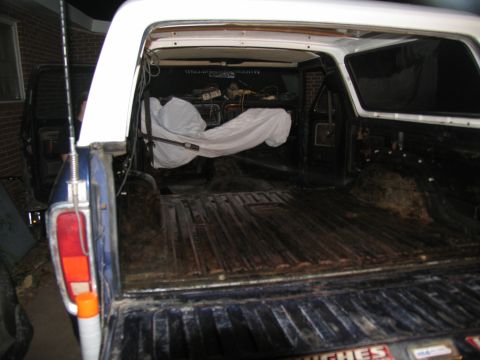 1978 Ford Bronco - Rear view of a 1978 Ford Bronco showing the cargo bed and interior, with another vehicle visible.