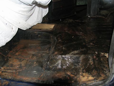 1978 Ford Bronco - The interior floor of a vehicle shows significant rust and dirt, indicating a need for restoration.