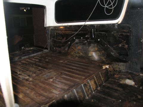 1978 Ford Bronco - The cargo area of the vehicle shows significant rust and wear on its floor and wheel wells.