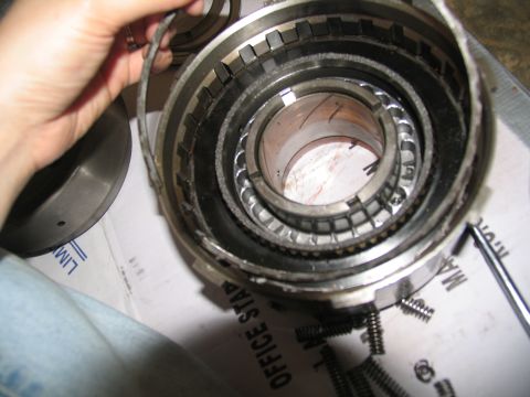 1978 Ford Bronco - A person is holding a ring from a disassembled transmission part, with springs scattered around.