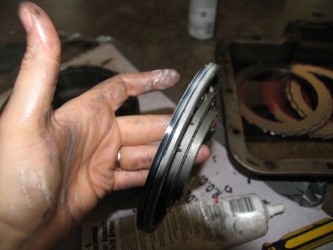 1978 Ford Bronco - Transmission clutch pack held by a greasy hand, with friction plates visible in a pan.