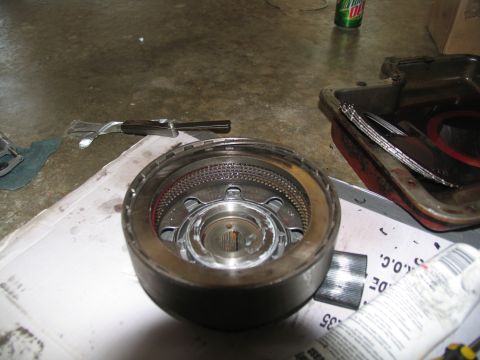1978 Ford Bronco - A close-up of a transmission component, likely during a rebuild, with various tools and a pan of fluid visible.