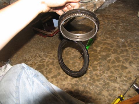 1978 Ford Bronco - Transmission planetary gear set and ring are held over a transmission pan during a rebuild.
