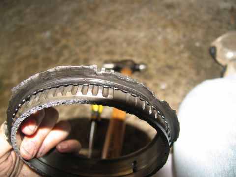 1978 Ford Bronco - A severely damaged transmission component, likely from a vehicle, is held up for inspection.
