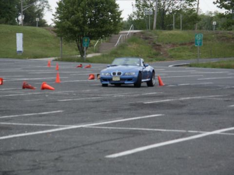 2001 Mercury Grand Marquis - A blue convertible sports car is driven through a parking lot marked with orange cones.