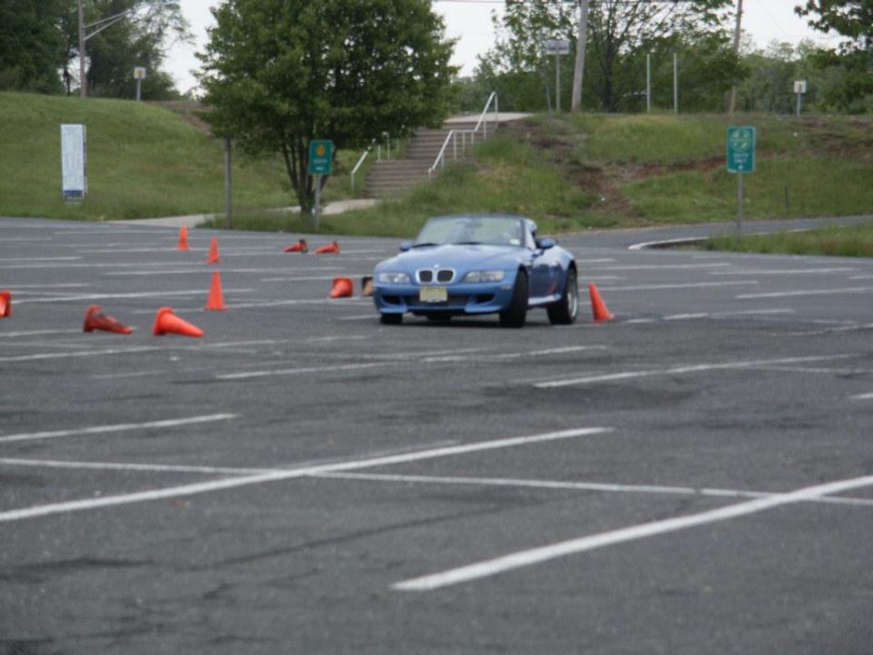 Blue convertible sports car navigating a cone course in a parking lot