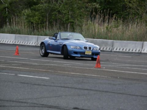 2001 Mercury Grand Marquis - A blue BMW convertible navigates an autocross course marked by orange cones.