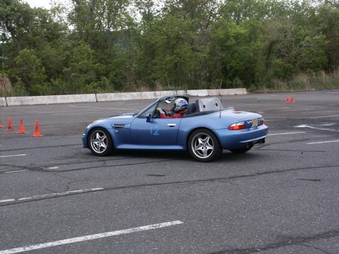 2001 Mercury Grand Marquis - A blue convertible sports car navigates a course marked by orange cones on a paved track.