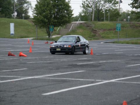 2001 Mercury Grand Marquis - A black BMW 3 Series sedan navigates an autocross course marked by orange cones.