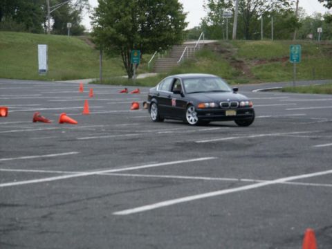 2001 Mercury Grand Marquis - A black BMW sedan navigates a course marked by orange cones on a paved lot.