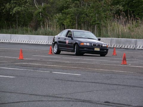 2001 Mercury Grand Marquis - A black BMW 3 Series sedan is seen on a race track during an autocross event, marked with the number 14.