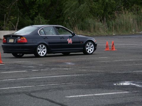 2001 Mercury Grand Marquis - A dark sedan with racing number 14 on its door navigates an autocross course marked by orange cones.