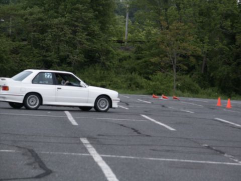 2001 Mercury Grand Marquis - White BMW E30 M3 navigates an autocross course marked with cones and painted lines.