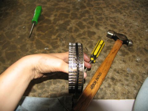 1978 Ford Bronco - Transmission gears being held by a hand, with tools nearby for repair.