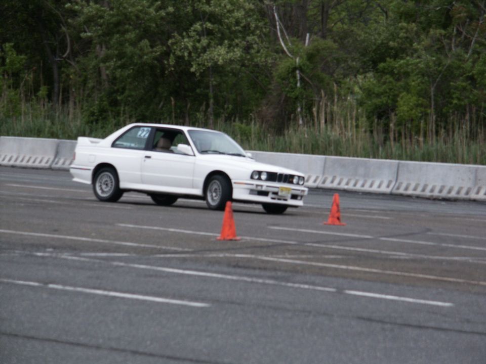 White BMW E30 M3 on a track with orange cones