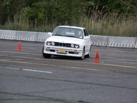 2001 Mercury Grand Marquis - White BMW E30 M3 navigates a course marked by orange traffic cones.