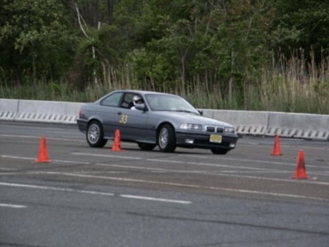 2001 Mercury Grand Marquis - A gray BMW E36 coupe navigates an autocross course marked by orange cones.