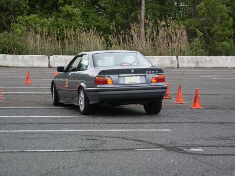 2001 Mercury Grand Marquis - Gray BMW 3 Series E36 coupe navigates an autocross course marked by orange cones.