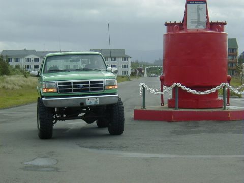 1994 Ford Explorer - This lifted green 1995 Ford F-150 4x4 features a distinctive grille and is seen in a coastal setting.