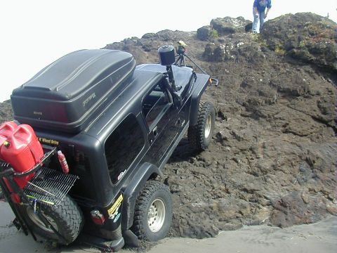 1994 Ford Explorer - An off-road SUV navigates a challenging rocky incline, equipped for adventure with extra fuel and storage.