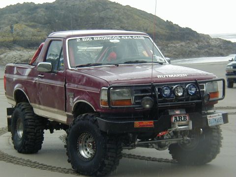 1994 Ford Explorer - This heavily modified truck, possibly a Ford Bronco, is seen on a sandy beach with off-road enhancements.