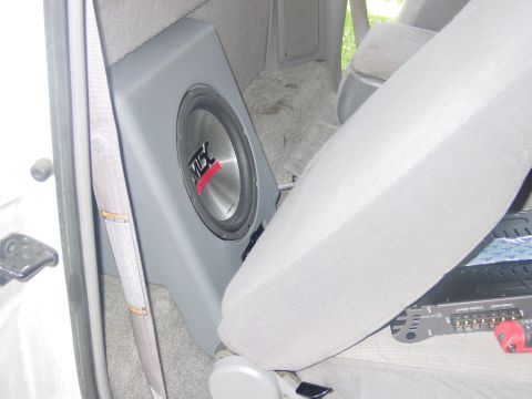 1997 Ford Ranger - The interior of a vehicle shows a custom-mounted subwoofer and an amplifier. The vehicle's model year is not discernible from the image.