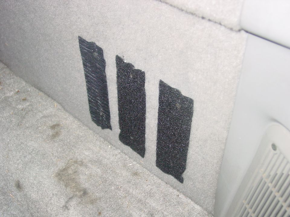 Interior panel with three strips of black tape on gray carpet