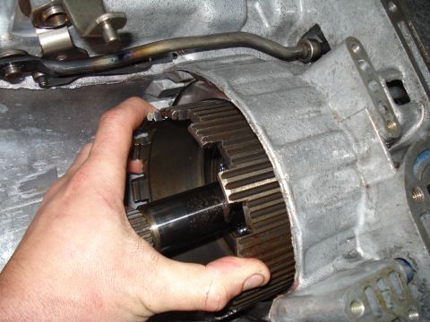 1984 Ford Bronco - Close-up of a hand holding a transmission component during a rebuild.