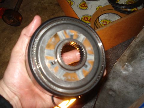 1984 Ford Bronco - A transmission clutch pack is held in hand, with other TCI transmission parts visible in the background.