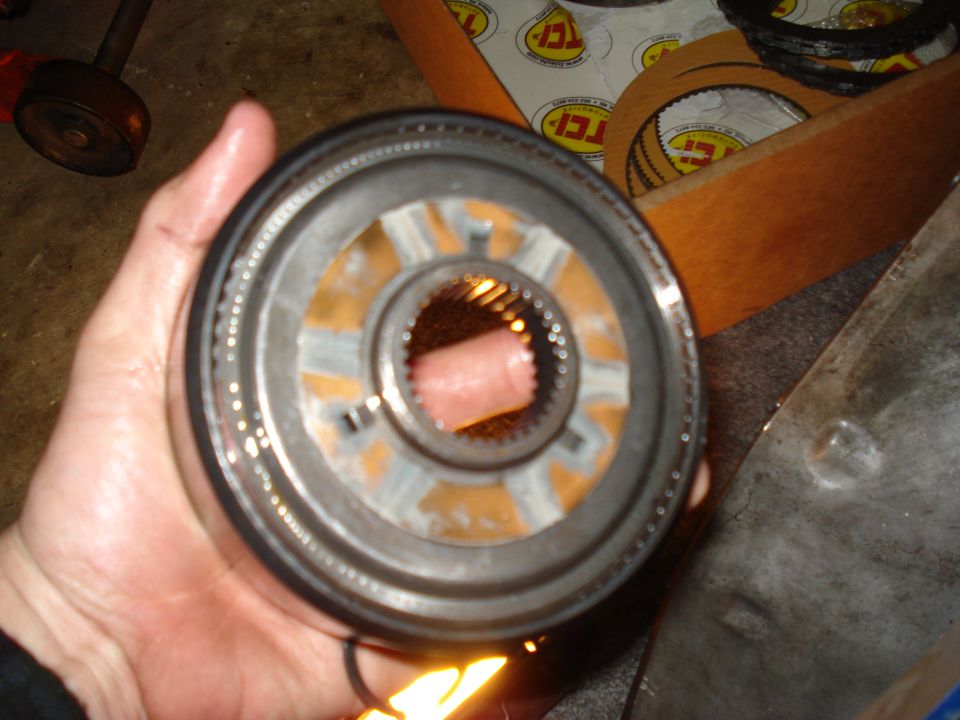 Transmission clutch pack held in hand, with TCI parts in background