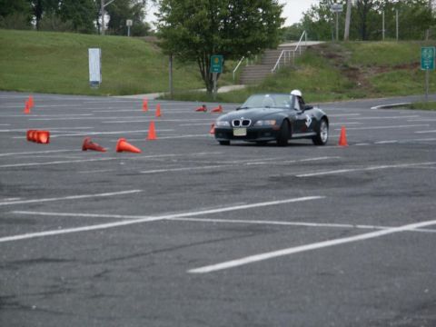 2001 Mercury Grand Marquis - A black BMW Z3 convertible navigates a course marked by orange traffic cones on a paved lot.