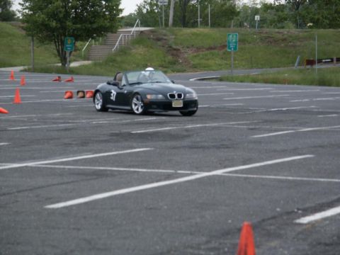 2001 Mercury Grand Marquis - A black BMW Z3 convertible navigates an autocross course marked by orange cones.