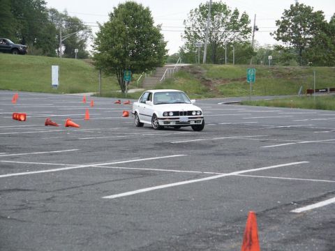 2001 Mercury Grand Marquis - White BMW E30 sedan participates in an autocross event on a marked course.