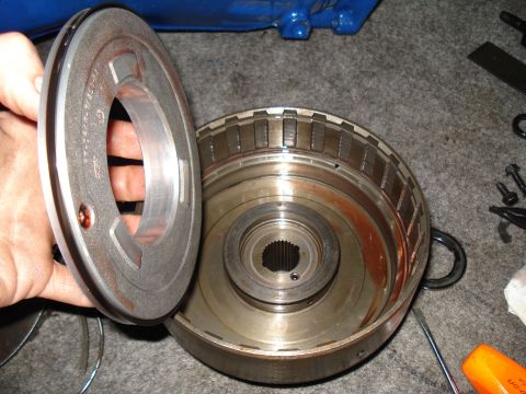 1984 Ford Bronco - A disassembled transmission torque converter part is shown, with a hand holding one of the components.