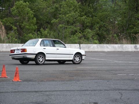 2001 Mercury Grand Marquis - White BMW E30 sedan on an asphalt course with orange cones visible.