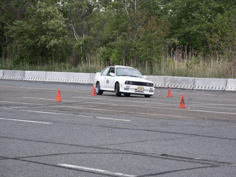 2001 Mercury Grand Marquis - A white BMW E30 M3 navigates an autocross course, marked with the number 49 on its door.