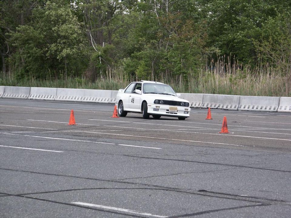 White BMW E30 M3 with number 49 on door, navigating autocross course
