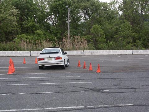 2001 Mercury Grand Marquis - A white BMW E30 M3 navigates an autocross course marked by orange cones.