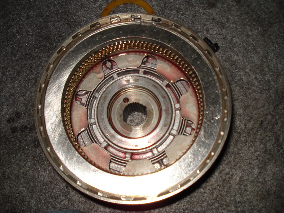 Transmission clutch pack with red fluid stains and metal teeth