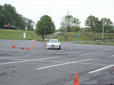 2001 Mercury Grand Marquis - A white BMW E36 coupe navigates a course marked by orange cones in a large asphalt lot.