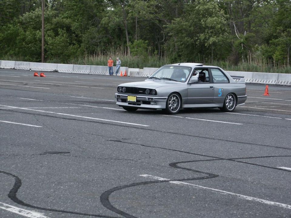 Silver BMW E30 M3 with number 51 on door, on racetrack. Year 1988