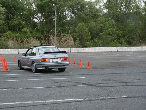 2001 Mercury Grand Marquis - A silver BMW M3 navigates an autocross course, marked by orange cones.