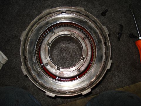1984 Ford Bronco - This is a close-up view of a transmission drum, showing ball bearings and some red fluid. Tools are nearby.
