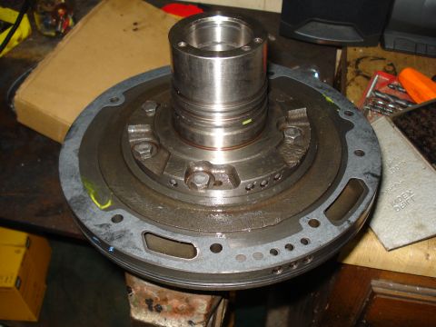 1984 Ford Bronco - A transmission torque converter is shown disassembled on a workbench, with various tools and parts visible in the background.