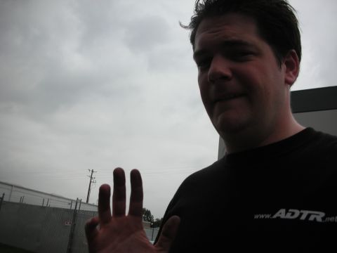 1992 Ford Crown Victoria - A man wearing a black t-shirt with a website logo on it raises his hand.