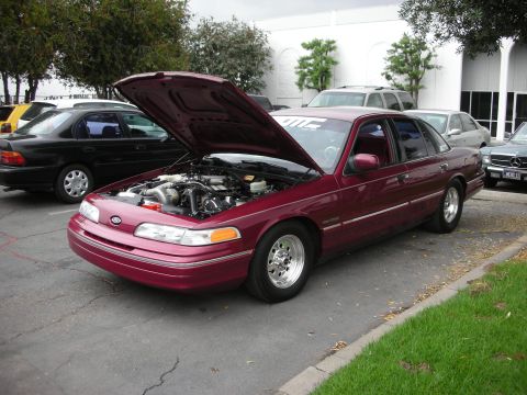 1992 Ford Crown Victoria - 1992 Ford Crown Victoria with its hood open, revealing the engine bay and turbo setup.
