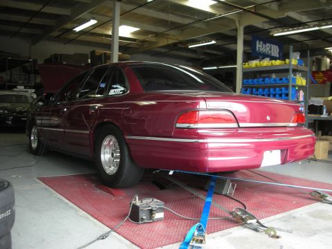 1992 Ford Crown Victoria - A maroon 1992 Ford Crown Victoria is positioned on a dynamometer for testing.