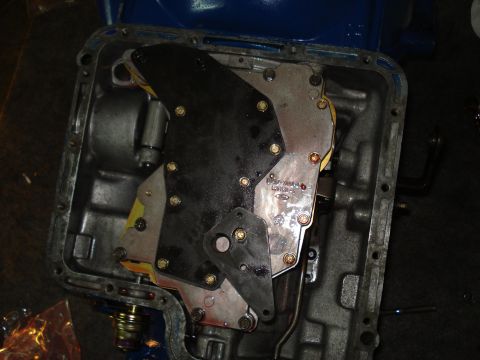 1984 Ford Bronco - Close-up view of a transmission valve body, showing internal components and assembly.