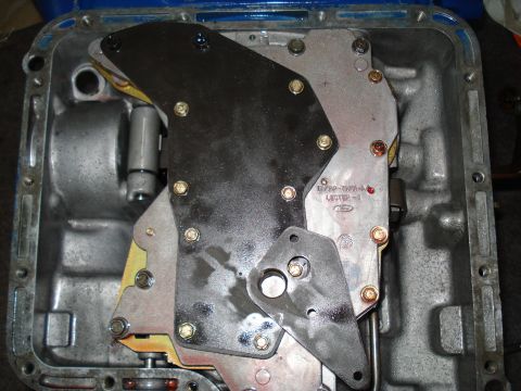 1984 Ford Bronco - Close-up of a transmission valve body, showing internal components and a Ford logo.