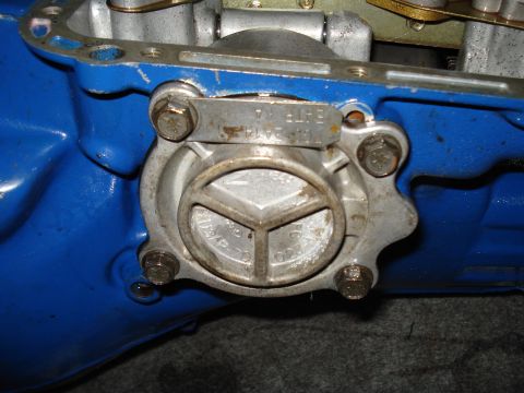 1984 Ford Bronco - Close-up view of a metal transmission component with visible stamped markings and bolts.